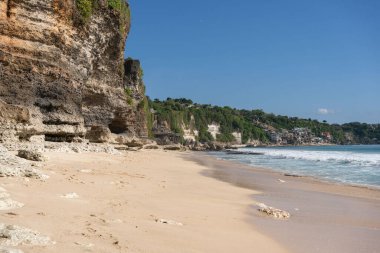 Kayalık dağları olan bir kumsal ve güneşli bir günde Hint okyanusunun berrak suları. . 