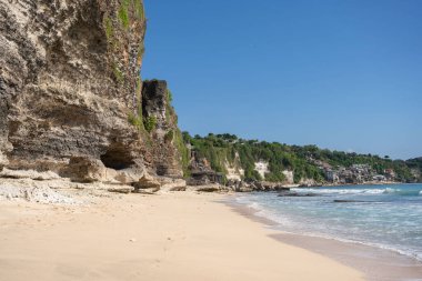Kayalık dağları olan bir kumsal ve güneşli bir günde Hint okyanusunun berrak suları. . 