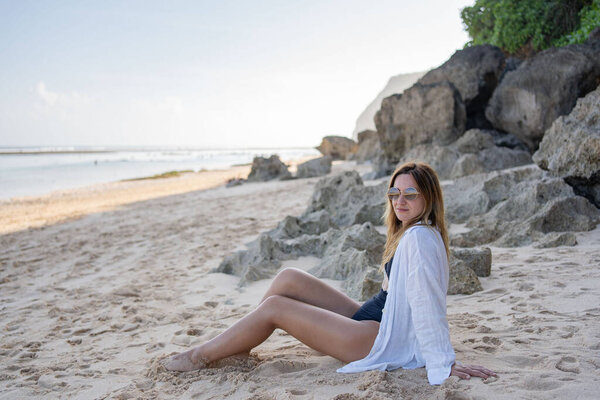 Young woman sitting on the beach alone, relax and enjoy nature