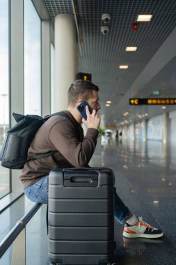  Havaalanında cep telefonuyla konuşan bir adamın portresi, terminalde uçmayı beklerken telefonla konuşmaktan zevk alan bir adam.. 