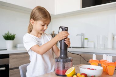 Evde dondurma yapan kız çocuğu, meyveli lolipoplar.