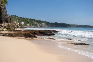 Kayalık dağları olan bir kumsal ve güneşli bir günde Hint okyanusunun berrak suları. . 