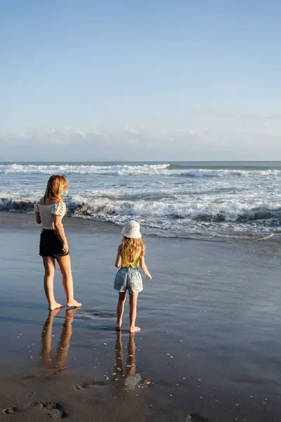 Мать Дочерью Веселятся Пляже Черным Песком Бали Бегают Волнам Наслаждаться — стоковое фото