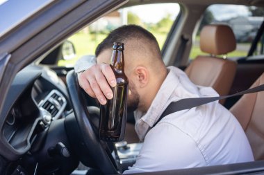 Adam araba sürerken içki içiyor. İçkili araba kullanma. - Evet. Yüksek kalite fotoğraf