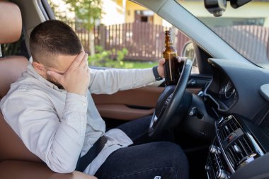 Adam araba sürerken içki içiyor. İçkili araba kullanma. - Evet. Yüksek kalite fotoğraf