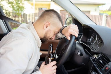 Adam araba sürerken içki içiyor. İçkili araba kullanma. - Evet. Yüksek kalite fotoğraf