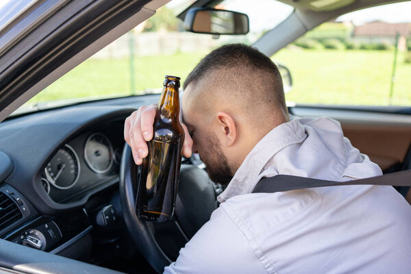 мужчина пьет алкоголь за рулём машины. Не пить и не водить машину. - Да. Высокое качество фото