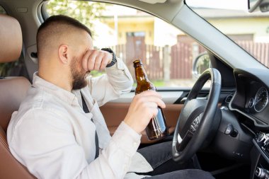 Adam araba sürerken içki içiyor. İçkili araba kullanma. - Evet. Yüksek kalite fotoğraf