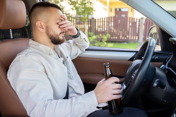 мужчина пьет алкоголь за рулём машины. Не пить и не водить машину. - Да. Высокое качество фото