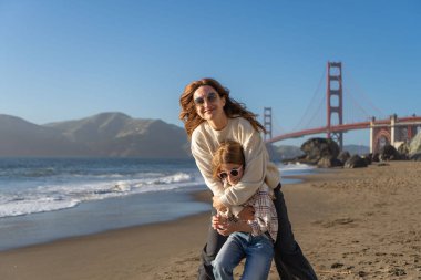 Anne ve kızı sahilde eğleniyor, kadınlara odaklanıyor.