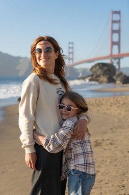 Anne ve kızı sahilde eğleniyor, kadınlara odaklanıyor.