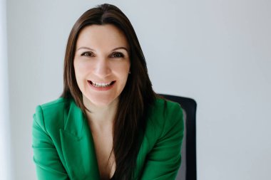 Ofiste yeşil ceketli mutlu bir kadının portresi..