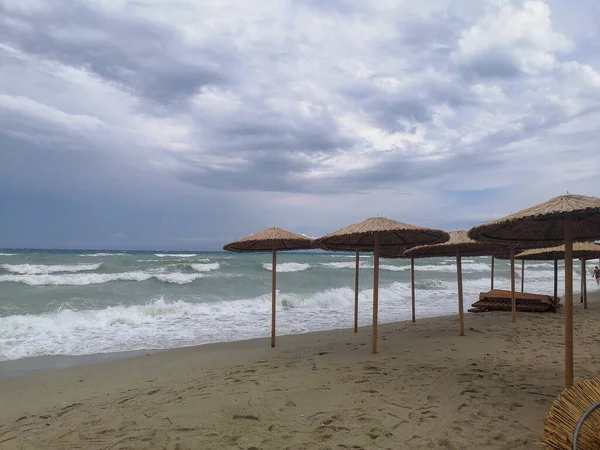 人のいない強い嵐の後の穏やかな海と孤独な傘だけ — ストック写真