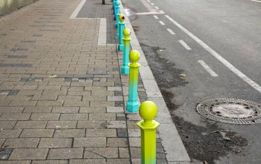 Belgrad 'da bir caddenin kaldırımındaki küçük sütunlar farklı renklerde boyanmış.