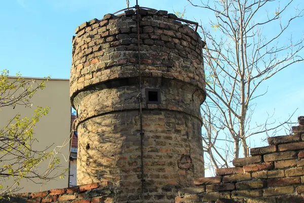 Fırınlanmış tuğladan yapılmış eski bir binada kule ve duvar.