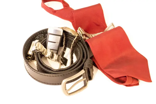 siyah deri kemer, saat, araba anahtarı ve kırmızı kravat.