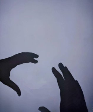 Gri arka planda çocukların ellerinin gölgesi