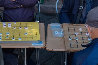 Güney Kore, Seul 'de kaldırımda mahjong oynayan yaşlı bir adam..