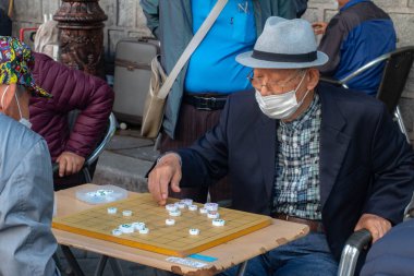 Güney Kore, Seul 'de kaldırımda mahjong oynayan yaşlı bir adam..