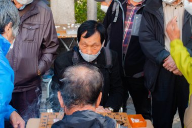 Güney Kore, Seul 'de kaldırımda mahjong oynayan yaşlı bir adam..