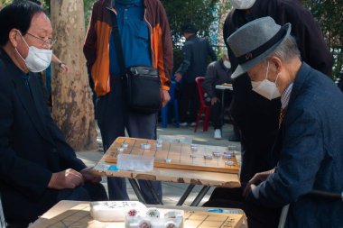 Güney Kore, Seul 'de kaldırımda mahjong oynayan yaşlı bir adam..