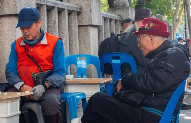 Güney Kore, Seul 'de kaldırımda mahjong oynayan yaşlı bir adam..