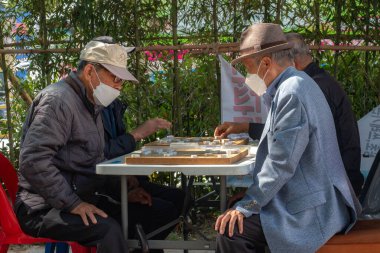 Güney Kore, Seul 'de kaldırımda mahjong oynayan yaşlı bir adam..