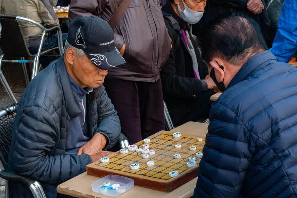 Güney Kore, Seul 'de kaldırımda mahjong oynayan yaşlı bir adam..