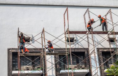Endonezya Cumhuriyeti 'nin bağımsızlığını kutlamak için Jakarta' daki miras binalarını boyayan işçiler.