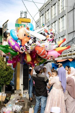 Jakarta, Endonezya - 31 Mart 2025: Matraman Raya yol kesişimindeki Kurban namazı sonrası balon satıcısı, Jatinegara, Jakarta.