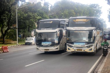 Jakarta, 19 Nisan 2025: Ulusal Anıt 'taki otobüsleri kullanarak ücretsiz bayram ulaşımı, Merkez Jakarta.
