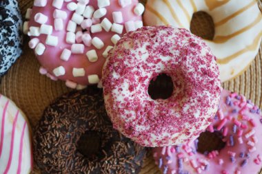 Pembe ve çikolatalı donutlar ve renkli serpiştirmeler.