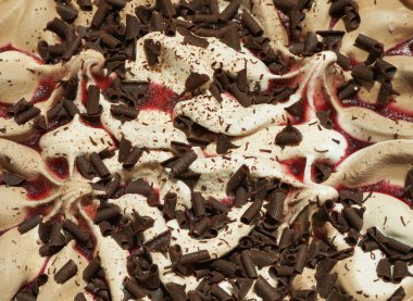 Çikolata ve vişne soslu beyaz dondurma ve çikolata parçacıkları.