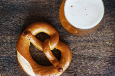 Bardakta filtresiz bira. Tahtadaki krakerin yanında.