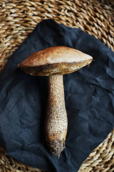 Suuri Syötävä Sieni Makaa Mustalla Lautasliinalla Pajukorissa — kuvapankkivalokuva
