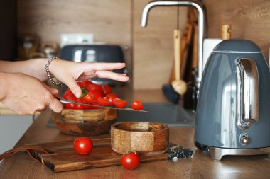 Modern ahşap bir mutfakta taze sebze dilimliyorum.