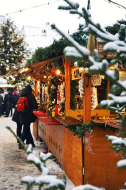 Noel dekorunun arka planında çeşitli tabak ve sosislerle ahşap büfe ve kış günlerinde insanlar