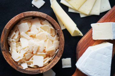 Parmesan peyniri, Camembert peyniri ahşap bir tahtada ve koyu bir arka planda kase.