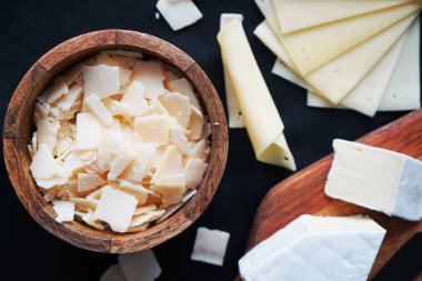 Parmesan peyniri, Camembert peyniri ahşap bir tahtada ve koyu bir arka planda kase.