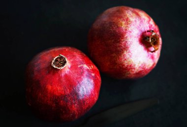 Koyu arkaplanda iki olgun nar.