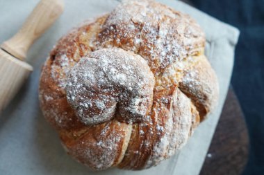 Koyu arkaplanda keten havlunun üzerinde taze ekmek.