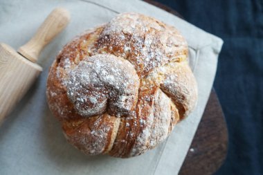 Koyu arkaplanda keten havlunun üzerinde taze ekmek.