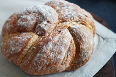 Koyu arkaplanda keten havlunun üzerinde taze ekmek.