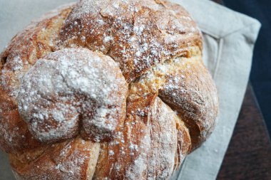 Koyu arkaplanda keten havlunun üzerinde taze ekmek.