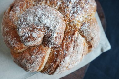 Koyu arkaplanda keten havlunun üzerinde taze ekmek.