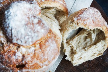 Koyu arkaplanda keten havlunun üzerinde taze ekmek.