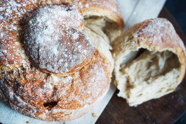 Koyu arkaplanda keten havlunun üzerinde taze ekmek.
