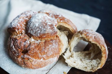 Koyu arkaplanda keten havlunun üzerinde taze ekmek.