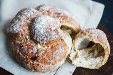 Koyu arkaplanda keten havlunun üzerinde taze ekmek.