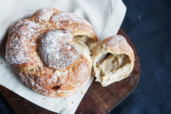 Koyu arkaplanda keten havlunun üzerinde taze ekmek.